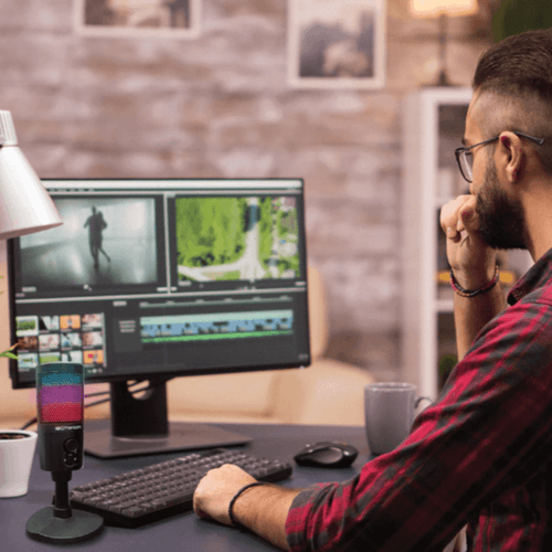 Streamer using Emerson USB RGB microphone at dual‑monitor setup