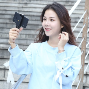 Person holding smartphone mounted on PULUZ mini tripod
