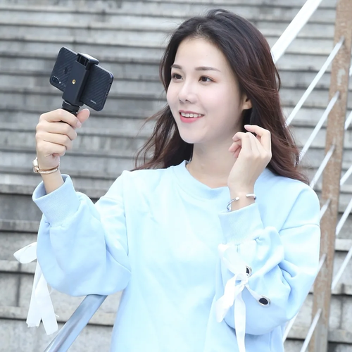 Person holding smartphone mounted on PULUZ mini tripod